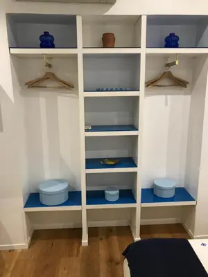 a closet with blue shelves and hangers at the blu and green apartment in Rome