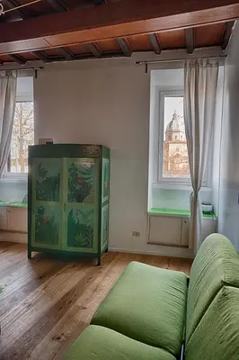 a living room with a green couch and a window at the blu and green apartment in Rome
