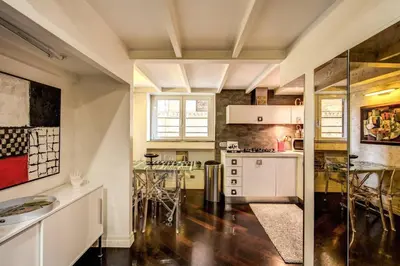 a kitchen with white cabinets and a table with chairs at Spacious Flat by Piazza Navona in Rome