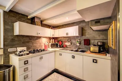 a kitchen with white cabinets and a stove top oven at Spacious Flat by Piazza Navona in Rome