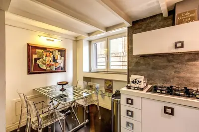 a kitchen with a counter and a table with chairs at Spacious Flat by Piazza Navona in Rome