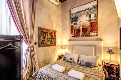 a bedroom with a bed and a painting on the wall at Spacious Flat by Piazza Navona in Rome