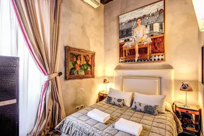 a bedroom with a bed and a painting on the wall at Spacious Flat by Piazza Navona in Rome