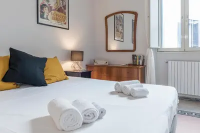 a bedroom with a white bed with towels on it at Casa Fellini - Charme Holidays in Rome
