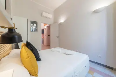 a bedroom with a white bed with yellow pillows at Casa Fellini - Charme Holidays in Rome