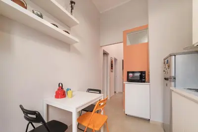 a small kitchen with a white table and chairs at Casa Fellini - Charme Holidays in Rome