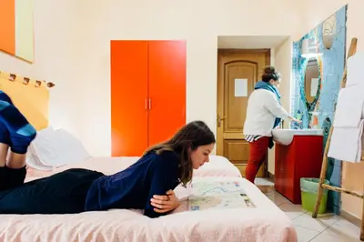 a woman laying on a bed in a room at The Beehive Hostel in Rome