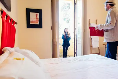 a man and a woman taking a picture of a bed at The Beehive Hostel in Rome