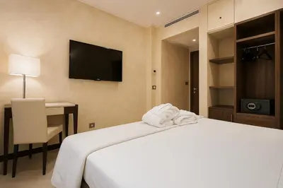 a bedroom with a bed and a desk and a television at Maison Candia Luxury House in Rome