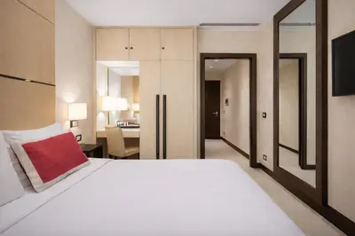 a bedroom with a large white bed with a red pillow at Maison Candia Luxury House in Rome