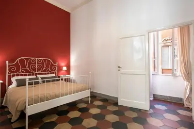 a bedroom with a bed and a red wall at Casa Coronari Holidays in Rome