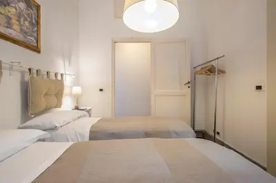 a bedroom with two beds and a light fixture at Casa Coronari Holidays in Rome