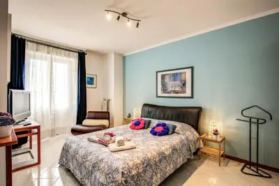 a bedroom with a bed and a chair and a television at Sunrise Apartment in Rome