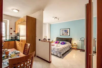 a bedroom with a bed and a table and a kitchen at Sunrise Apartment in Rome