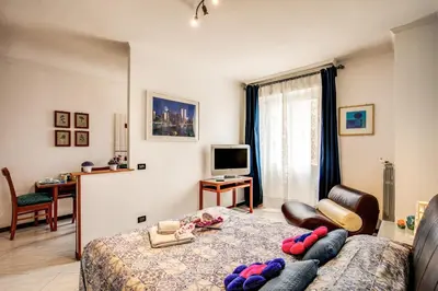 a bedroom with a bed and a tv and a couch at Sunrise Apartment in Rome