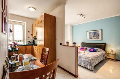 a kitchen and a bedroom with a bed and a table at Sunrise Apartment in Rome