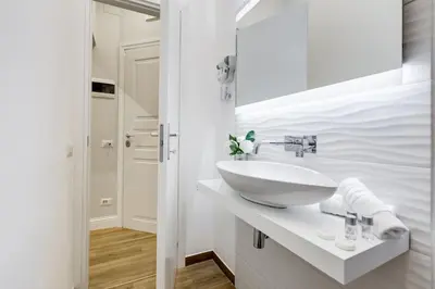 a white bathroom with a sink and a mirror at Opera Private Suites by Premium Suites Collection in Rome