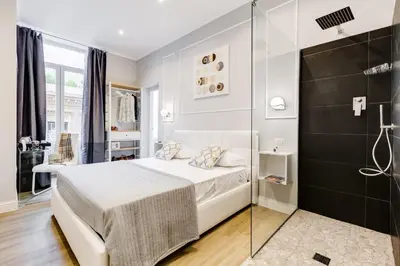 a bedroom with a white bed and a glass shower at Opera Private Suites by Premium Suites Collection in Rome