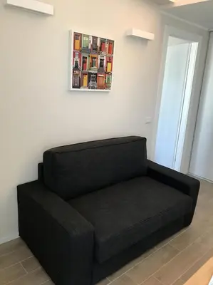 a black couch in a room with a picture on the wall at Giuly'S House Cozy & Comfy Apartment in Rome ....Real Rome !!! in Rome