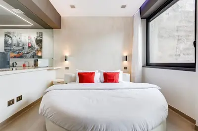 a bedroom with a large white bed with red pillows at EMERALD Luxury Suite Apartment in Rome