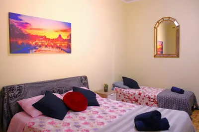 a bedroom with two beds and a painting on the wall at Roma Tiberius Suite in Rome