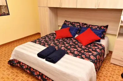 a bedroom with a bed with red and blue pillows at Roma Tiberius Suite in Rome