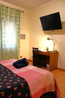 a bedroom with a bed and a desk with a television at Roma Tiberius Suite in Rome