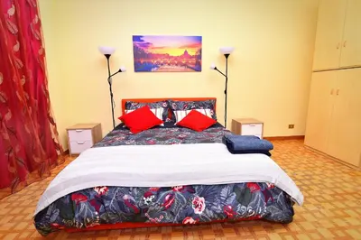 a bedroom with a large bed with red pillows at Roma Tiberius Suite in Rome