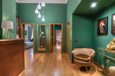 a living room with green walls and a chair at Hotel Paba in Rome