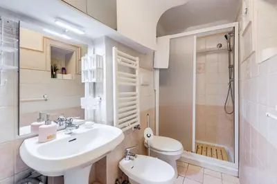 a white bathroom with a sink and a toilet at Colosseum Rione Monti 1 in Rome