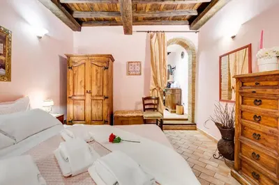 a bedroom with a large bed and a wooden dresser at Colosseum Rione Monti 1 in Rome