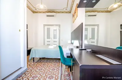 a room with a bed and a vanity with a mirror at El Dorado Colosseum in Rome