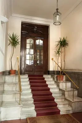 a lobby with stairs and a door with plants at El Dorado Colosseum in Rome