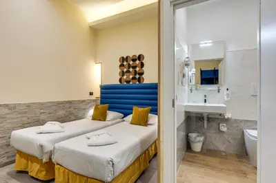 a hotel room with two beds and a bathroom at Seven in Rome