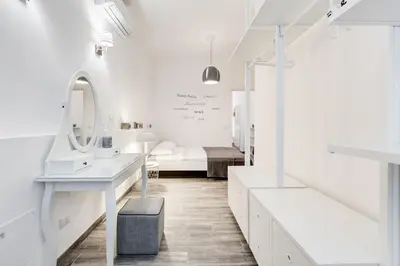 a white bathroom with a sink and a mirror at The Miki House in Rome