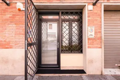 an open door to a brick building with a gate at The Miki House in Rome