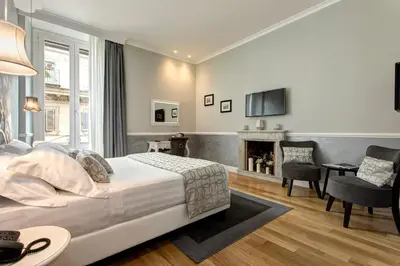 a bedroom with a bed and a living room with a fireplace at Relais de l'Opera in Rome