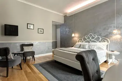a bedroom with a white bed and a gray wall at Relais de l'Opera in Rome