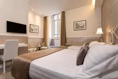 a hotel room with a large bed and a television at Relais de l'Opera in Rome