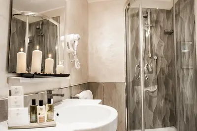 a bathroom with two sinks and a shower with candles at Relais de l'Opera in Rome