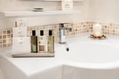 a bathroom counter with a sink with products on it at Relais de l'Opera in Rome