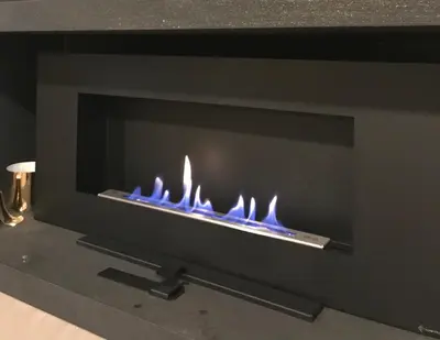 a fireplace with blue flames on a black wall at CasAphrodite in Rome