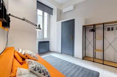 a bedroom with an orange bed and a blue door at TRIDENTE Apartment in Rome