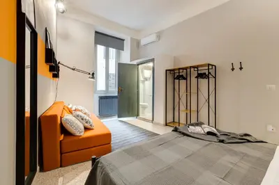 a bedroom with an orange bed and a chair at TRIDENTE Apartment in Rome