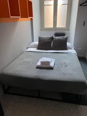 a bed with a towel on it in a room at TRIDENTE Apartment in Rome