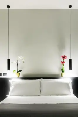 a white bed with two pillows and two plants at Etruscan Luxury Suites in Rome