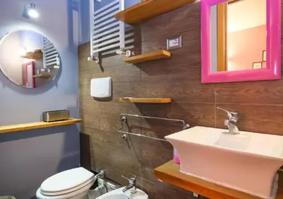 a bathroom with a sink and a toilet and a mirror at Aida Charming Rooms in Rome