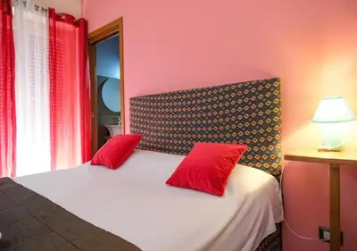 a bedroom with a bed with two red pillows at Aida Charming Rooms in Rome