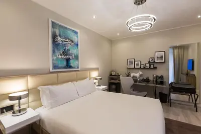 a bedroom with a white bed and a desk with a computer at Clementi Portrait in Rome