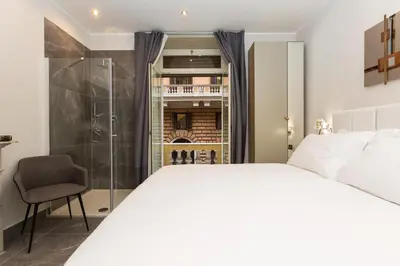 a bedroom with a white bed and a shower at Clementi Portrait in Rome